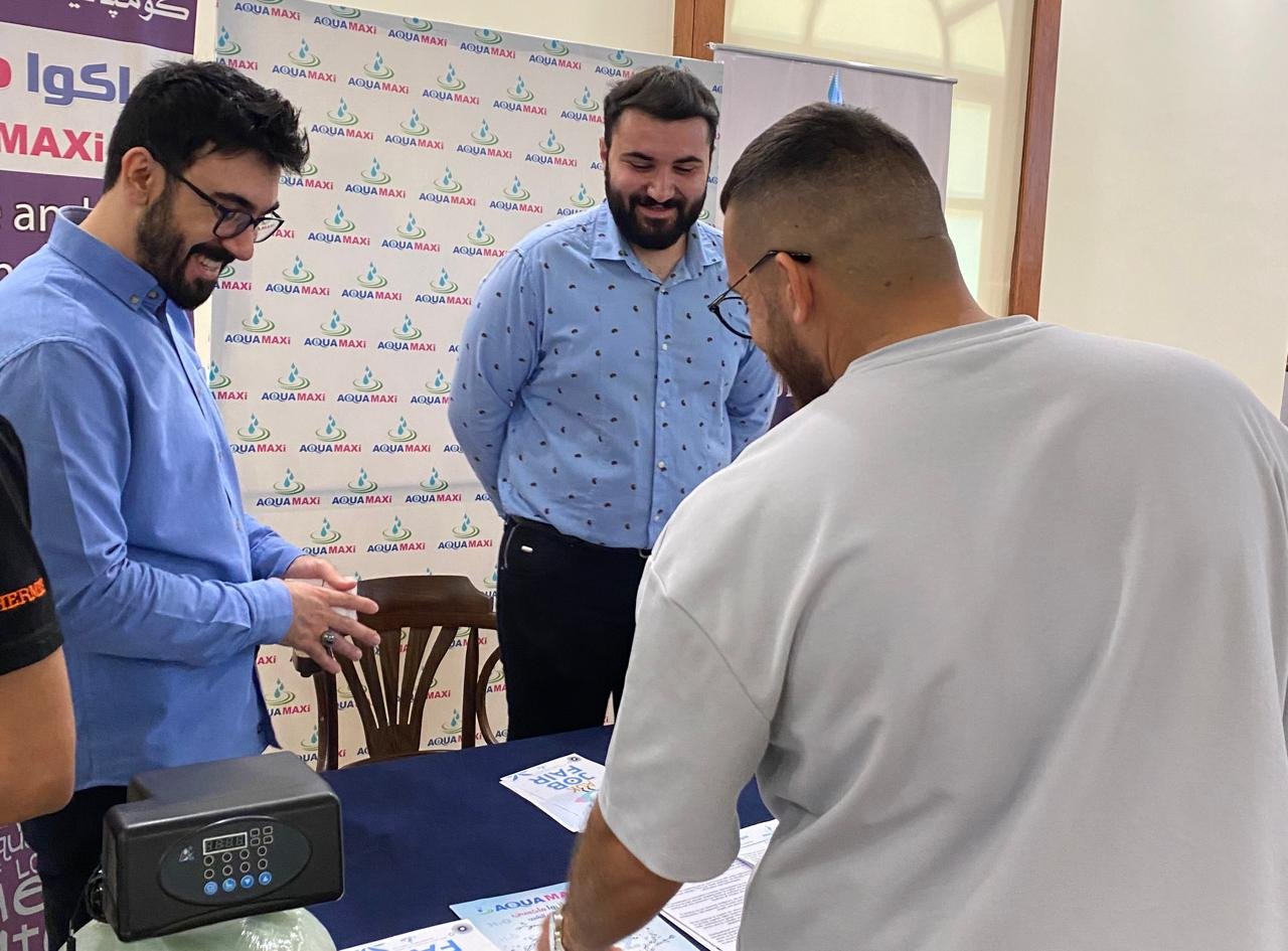 AQUA MAXI team meeting visitors at an exhibition